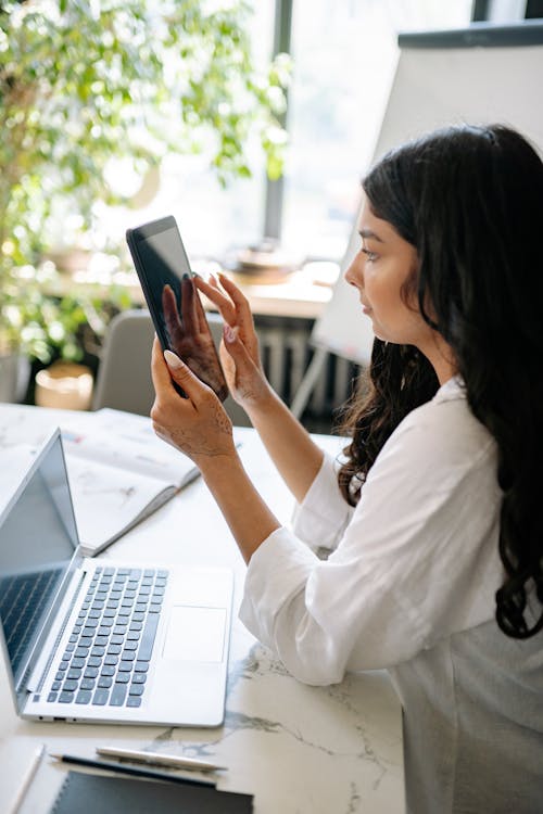 Person with tablet and laptop