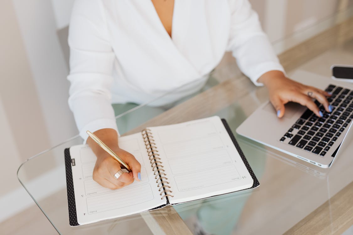 Person writing quality content in notebook