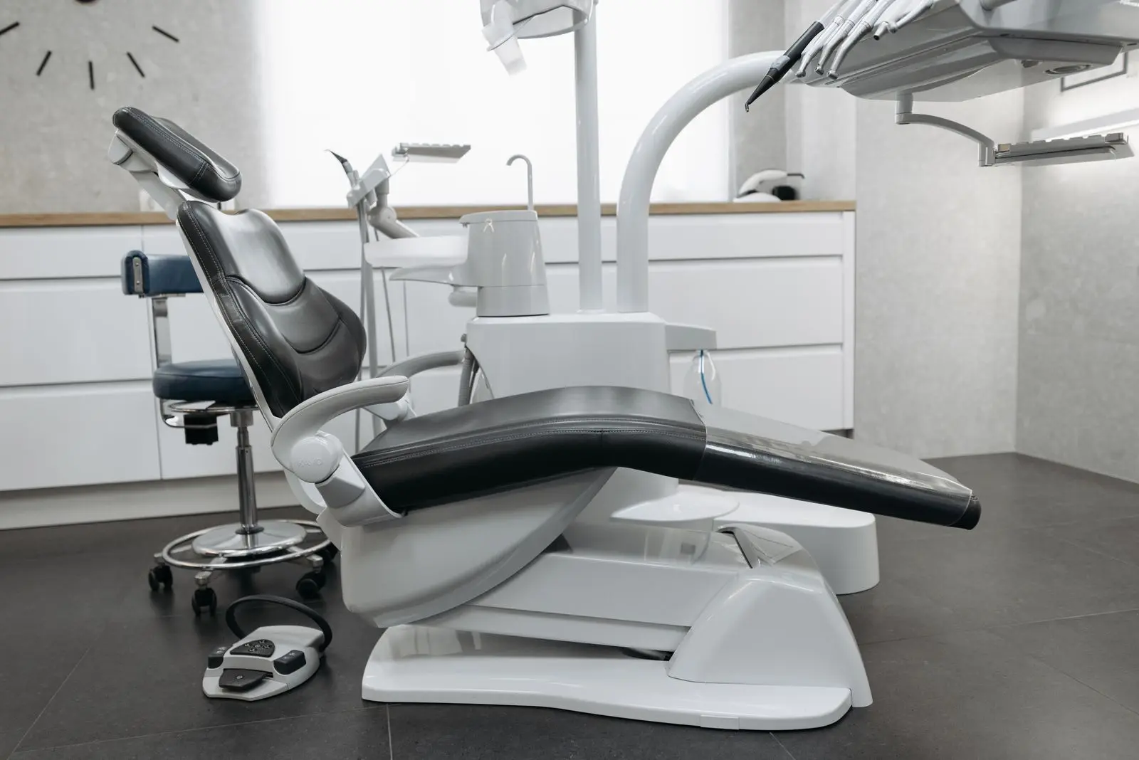 Empty dental treatment room with a dental chair and overhead light
